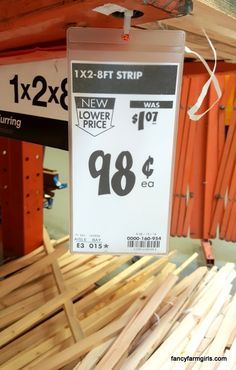 a price sign hanging from the ceiling in a store with wooden planks behind it