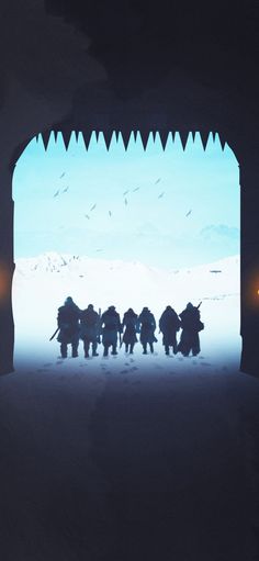 a group of people walking through a tunnel in the snow at night with lights on