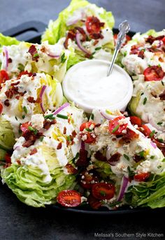 lettuce and tomato salad with ranch dressing in a black platter on a table