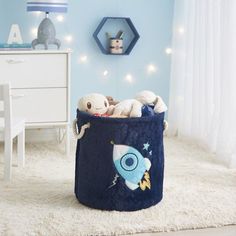 a child's toy storage bin with stuffed animals in it on a white rug