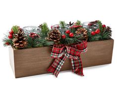 a wooden planter with pine cones and berries on the top, tied with a red ribbon