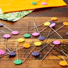 the wooden table is covered with colorful pins