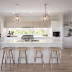 a kitchen with white counter tops and wooden stools