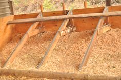 an animal pen filled with hay and wooden slats