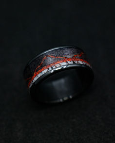 A "The Expedition" men's wedding band from Staghead Designs peeks out of the shadows. This black zirconium ring features dark maple wood, elk antler, & red opal mountains. Whiskey Barrel Wedding Ring, Engraved Wedding Ring, Green Engagement Rings, Antler Wedding Rings, Alternative Wedding Ring, Non Traditional Wedding Ring, Antler Wedding Band, Wood Engagement Ring, Handcrafted Engagement Ring