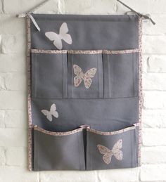 a gray wall hanging with butterflies on it