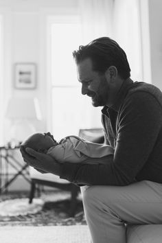 a man holding a baby in his arms