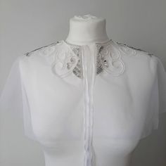 Bridal cape. Elegant handmade short shoulder cape with beaded embroidery. Wedding bolero. Boho wedding shoulder cape. Bridal cape tulle. Handmade short shoulder cape exudes elegance and makes the bride feel unsurpassed. The cape drapes gracefully over the shoulders, creating an ethereal and romantic aura. The beauty of this cape lies in its exquisite embroidery. The entire surface is adorned with intricate beadwork, delicate sequins, and sparkling stones. The beads shimmer in the light, creating a subtle yet enchanting sparkle. The closure a delicate ribbon, adding a touch of femininity and allowing for an adjustable fit. The cape is versatile enough to be worn throughout the wedding day. It can be draped over the bride's shoulders during the ceremony for a regal look and then removed. Thi Bridal Shoulder Cape, Elegant Shawl Capelet For Weddings, Elegant Fitted Wedding Cape, Fitted Capelet With Cape Sleeves For Wedding, Elegant Wedding Capelet Shawl, White Embroidered Dress With Cape Sleeves, Elegant Wedding Shawl Capelet, Elegant White Capelet For Wedding, Elegant White Cape With Cape Sleeves