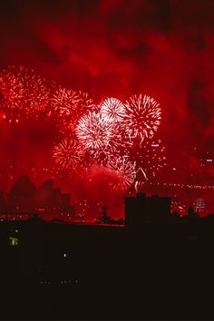 fireworks are lit up in the night sky above a cityscape with buildings and skyscrapers