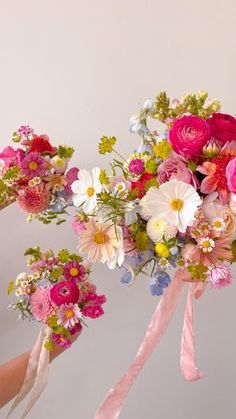 three bridesmaids holding bouquets of pink and white flowers in their hands with ribbons