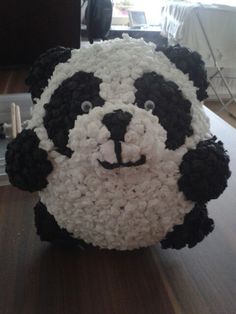 a stuffed panda bear made out of crochet on top of a wooden table