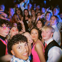 a group of young people standing next to each other in front of a crowd at a party