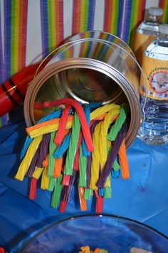 there are many colorful sticks in the bowl and on the table next to the water bottle