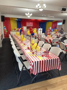 a room filled with tables covered in red and white striped tablecloths