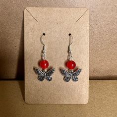 MKW Emporium Silver Handmade Beaded Charm Earrings Red Bead with a Silver Butterfly Charm #97 These are silver earrings with a red bead. It has a silver butterfly charm etched with black wings. All of the Earring Hooks used are Hypoallergenic Ear Hooks with clear silicone backings. Made of quality nickel-free and lead-free metal alloy or 925 silver-plated copper. Most Earrings can be customized and created just for you! If you have a specific color or style that you would like to see, please feel free to reach out so that your item can be made and listed. Most Earrings can be converted to clip-ons.  Please feel free to reach out with any questions. White Christmas Stockings, Winter Earrings, Halloween Charms, Black Wings, Heart Drop Earrings, Earrings Red, Silver Butterfly, Blue Quartz, Butterfly Charm