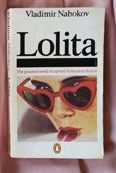 the book lollita is laying on top of a pink bed sheet and it's cover