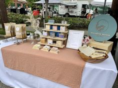 a table with soaps and other items on it in front of a white tent