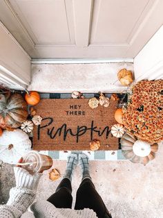 someone standing in front of a welcome mat that says hey there pumpkin