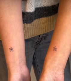 two people with matching tattoos on their arms, one has a clover tattoo on the other