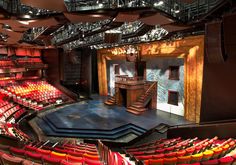 an empty theater with red seats and stairs leading up to the balcony area that overlooks the stage