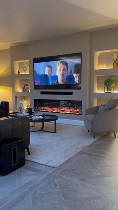 a living room filled with furniture and a flat screen tv mounted on the wall above a fireplace