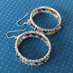 Ribbon Hoop Earrings New beaded earrings at WorkofHeart.  Stunning multicolored crystal beaded earrings.  Big bold bright hoop earrings made with silver seed beads and multicolored crystal beads. If you love to receive compliments on your jewelry, just wait until you wear these  These are possibly one of the most beautiful pair or earrings in my shop.  Each bead is individually and expertly woven to make these beautiful earrings. The french hook earwires are 14kt gold filled.  These luxurious earrings measure 2 inches total. The hoops are 1.5 inches. Stunningly beautiful for any occassion and lots of bling for a night out on the town.  Please see more items from Work of Heart at http://workofheart.etsy/com Thanks for looking and please stop by again. Multicolor Crystal Jewelry With Spacer Beads, Multicolor Small Hoop Jewelry With Spacer Beads, Silver Earrings With Colorful Beads, Silver Beaded Earrings With Colorful Beads, Multicolor Hoop Jewelry With Spacer Beads, Silver Round Beaded Earrings With Colorful Beads, Silver Small Hoop Earrings With Colorful Beads, Small Silver Hoop Earrings With Colorful Beads, Multicolor Crystal Beaded Earrings