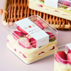 strawberries and cream desserts in plastic containers on a table