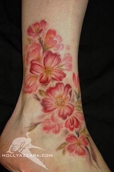 a woman's foot with pink flowers painted on the top and bottom of it