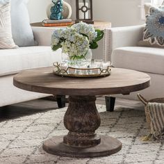 a living room filled with furniture and flowers on top of a coffee table in front of a white couch