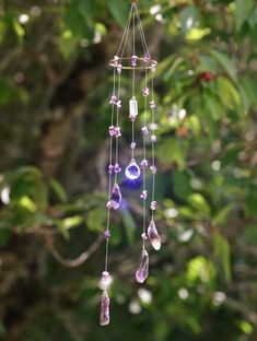 a wind chime hanging from a tree in the forest