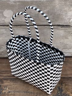 a black and white basket sitting on top of a wooden floor