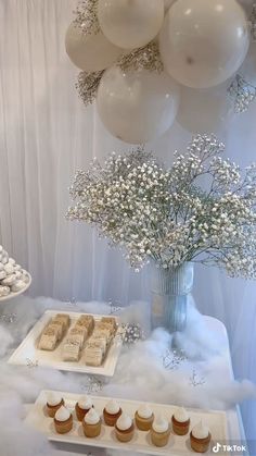 dessert table with cupcakes, cake and balloons in the air at a wedding reception