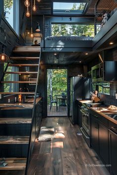 an open kitchen with stairs leading up to the loft