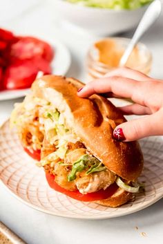 a person is holding onto a sandwich on a plate