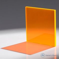 an orange glass block sitting on top of a white table