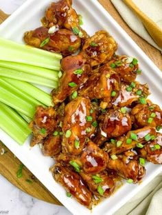 chicken wings and celery on a plate with chopsticks next to it