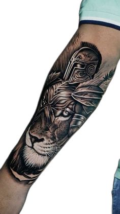 a man's arm with a lion and helmet tattoo on the left side of his arm