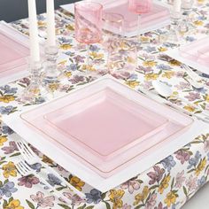 the table is set with pink plates and place settings for two people to sit at