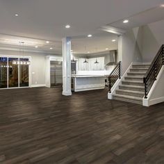 an empty living room with stairs leading up to the second floor