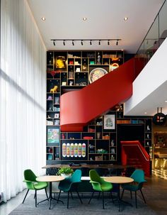 a room with tables, chairs and a spiral staircase