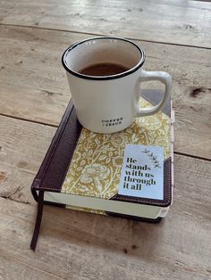 a cup of coffee sitting on top of a book