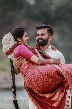 a man carrying a woman on his back while she is wearing a red sari