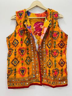 Fulkari open vest is made from a soft traditional indian phulkari handmade scarf. the scarves are used for festive occasions like weddings. the phulkari scarf is hand embroidered and embellished by indian artisan. vest has long wide vest coat. the vest jacket has an open front, and the length is normal jacket. indian chanderi silk phulkari hand work boho fashion kimono robe jacket. indian embroidered boho style beach wear body cover up. reversible vest jackets/coat you can wear this one in both side one side is phulkari embroidered and other side is cotton printed. *buy it for the holidays! looks fabulous over a long silk tank dress or palazzo pants. or wear it with to install jeans and boots. measurements: colour: as per the picture approx length : 23 inch / 60 cm bust approx : 40 inch / Multicolor Nehru Jacket For Navratri, Bohemian Outerwear With Zari Work For Festive Occasions, Bohemian Festive Outerwear With Zari Work, Festive Traditional Outerwear With Mirror Work, Festive Outerwear With Handwork, Traditional Multicolor Festive Vest, Festive Multicolor Embroidered Vest, Bollywood Nehru Jacket With Multicolor Embroidery For Festivals, Bohemian Handwork Choli For Festive Occasions