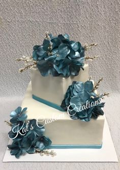 two tiered wedding cake with blue flowers on top