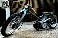 the motorcycle is parked on the side of the road in front of an open garage door