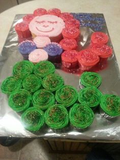 some cupcakes are sitting on top of tin foil with green and red icing