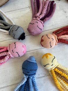 crocheted toys are arranged on a white wooden surface