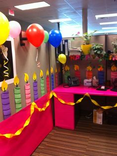 an office cubicle decorated with balloons and streamers for birthdays or other special events