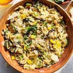 a wooden bowl filled with pasta and vegetables