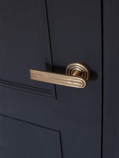 a close up of a door handle on a dark blue door with gold trimming